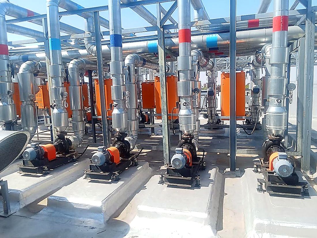 Chilled water pump skids with insulated headers in a commercial HVAC plant room
