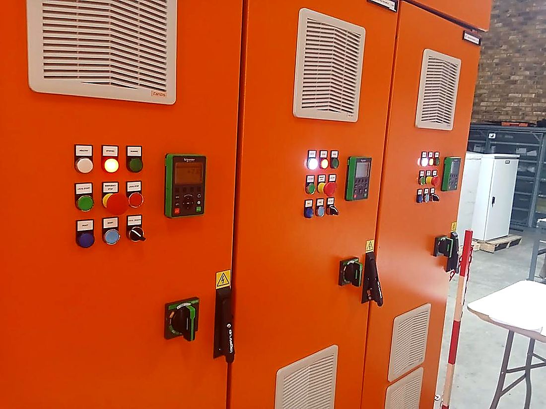 Close up of an orange motor control centre panel with selector switches and protection relays
