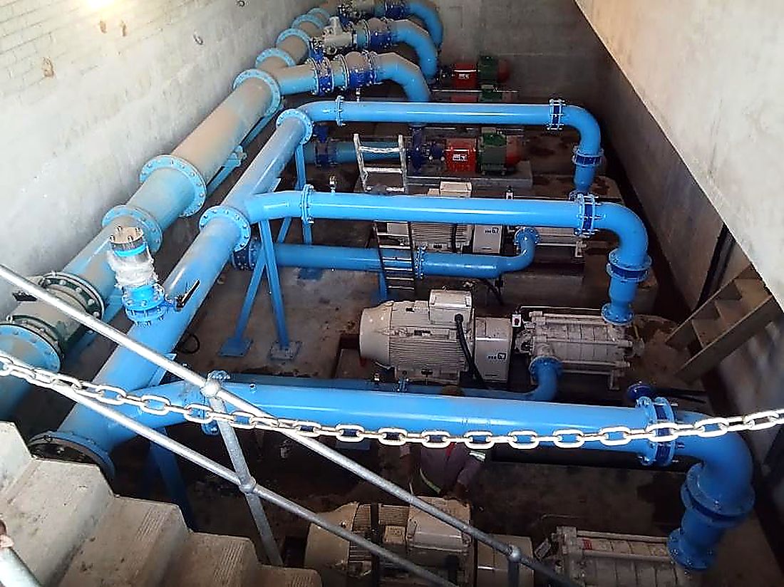 Twin pump sets and blue pipework installed in a below-ground pump chamber