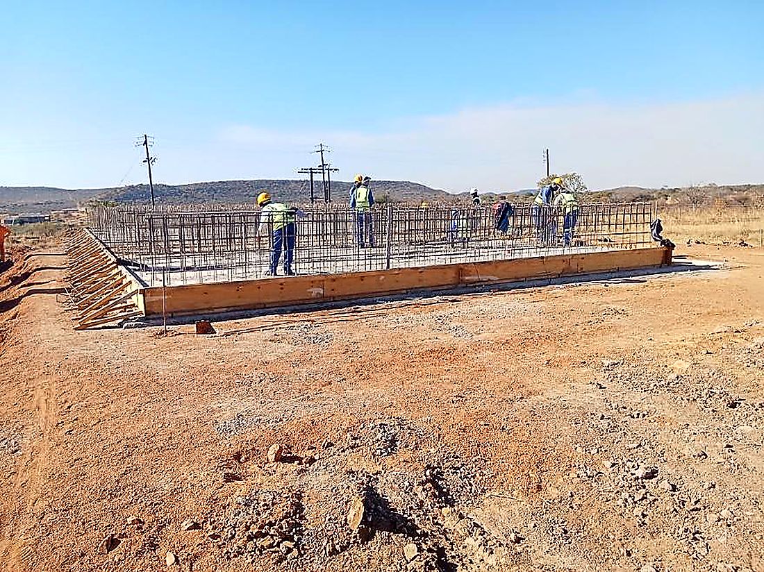 Steel fixing team working along a long reinforced concrete wall base