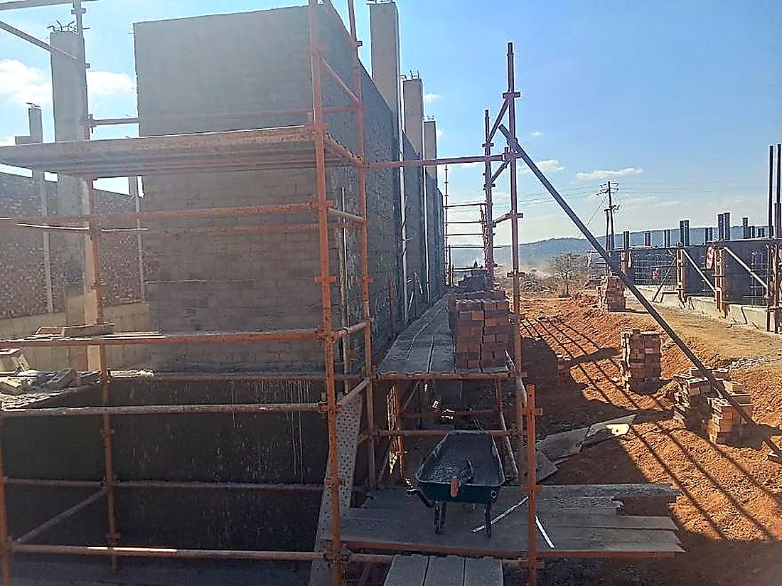 Reinforced concrete walls rising behind access scaffolding on a water infrastructure site